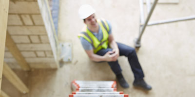 A worker holder his knee after falling from a ladder.